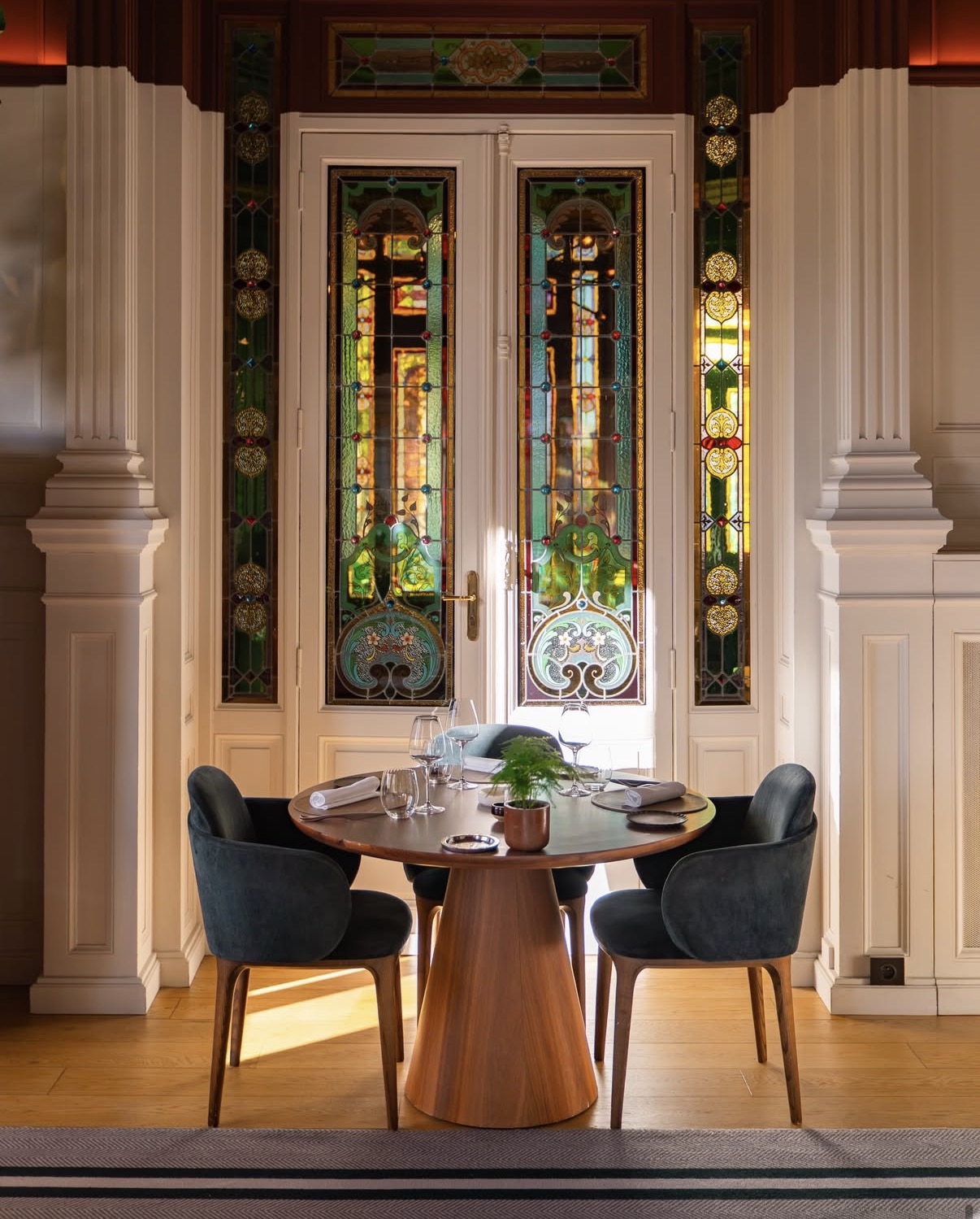 Table du restaurant du Château Grand Barrail devant les portes ornées de vitraux