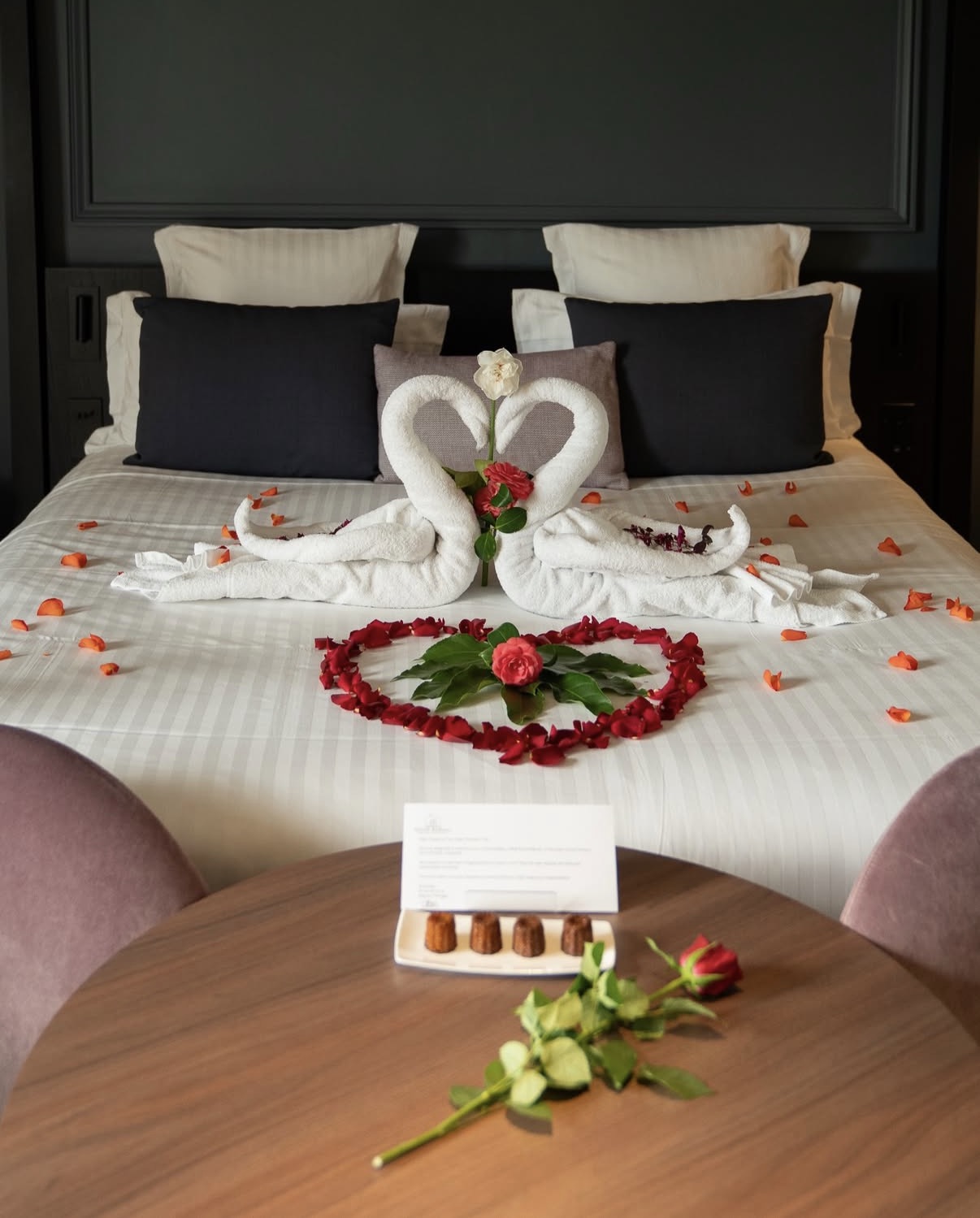 Chambre du Château Grand Barrail avec cygnes en serviettes et pétales de roses pour un séjour romantique