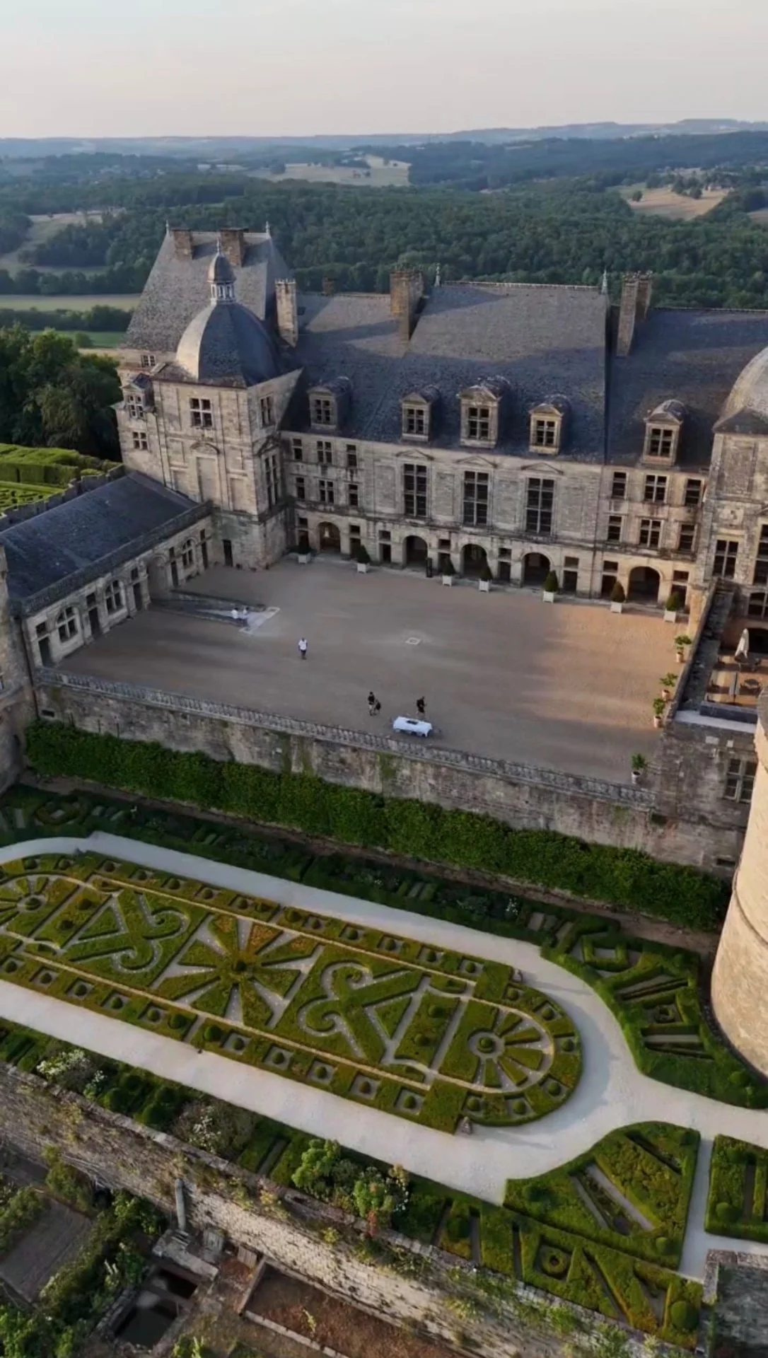 Façade classique et cour d’honneur du château de Hautefort au-dessus des jardins