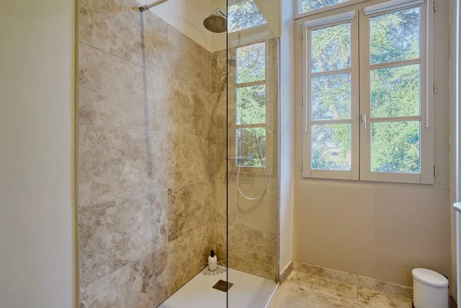 Salle d'eau avec douche à l'italienne ouverte sur la verdure au Clos Boissière