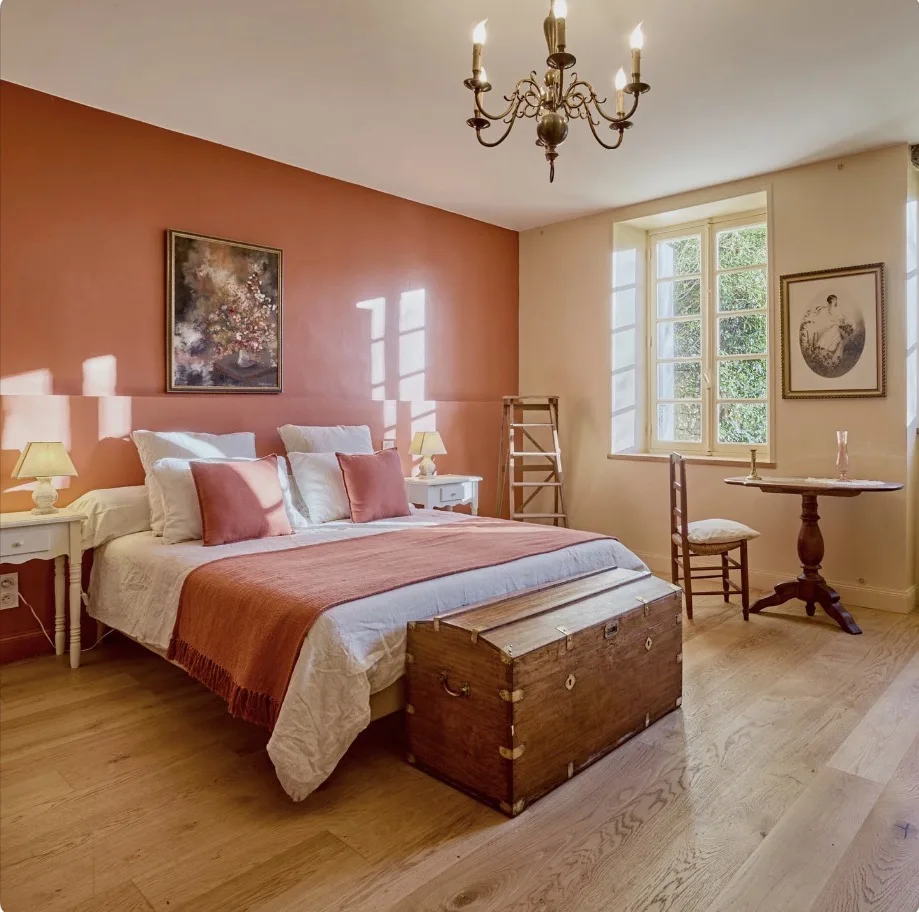 Chambre aux murs terracotta avec lustre au Clos Boissière