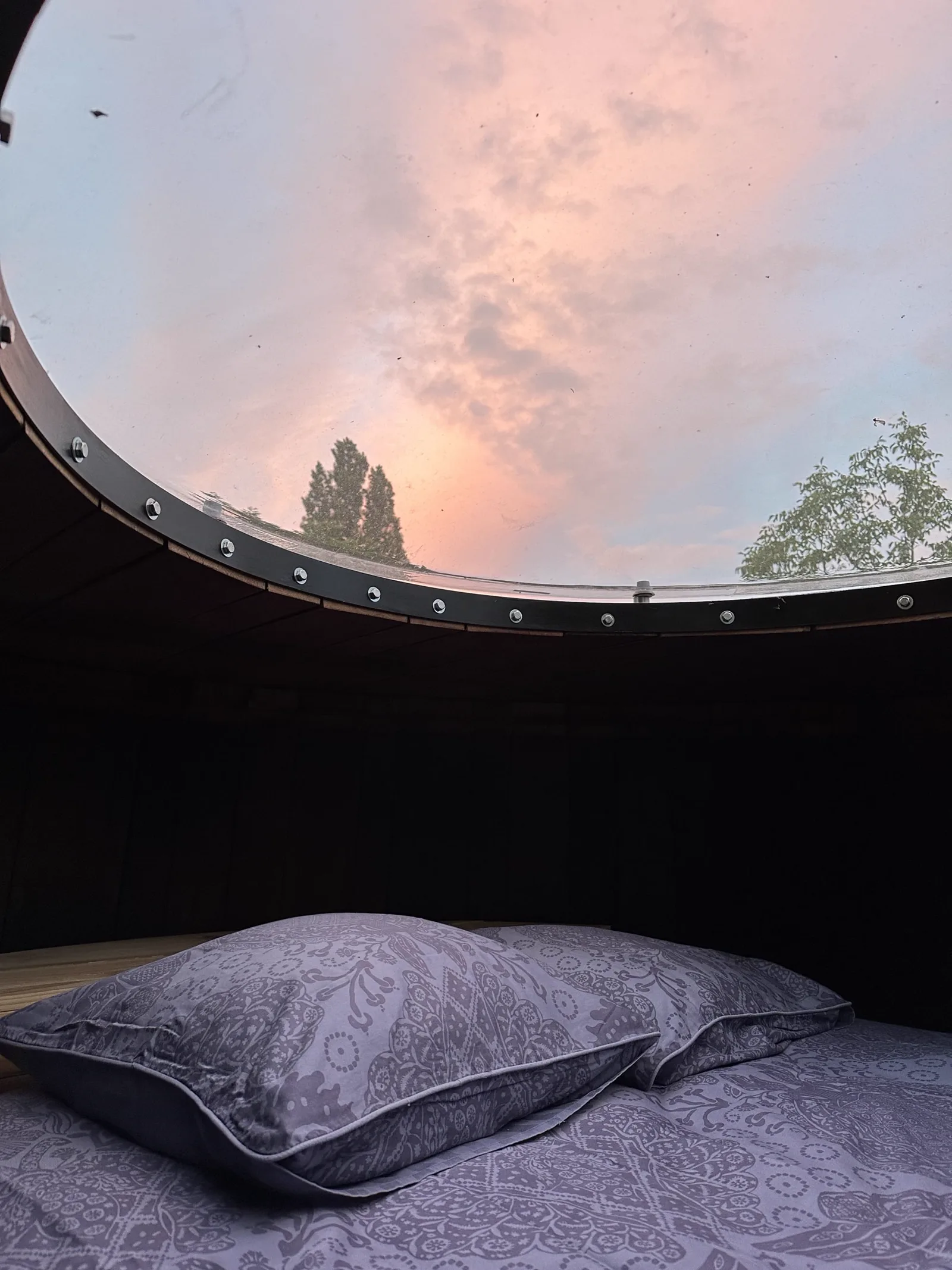 Le lit double sous le hublot ouvert sur le ciel dans le foudre Anita