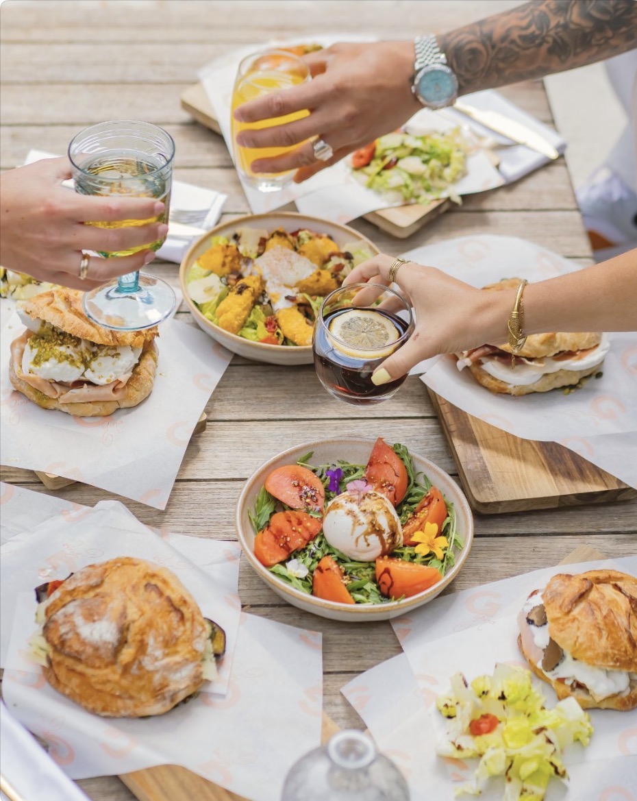 Table de brunch partagée chez GINA Bordeaux : burrata, sandwichs garnis et verres levés