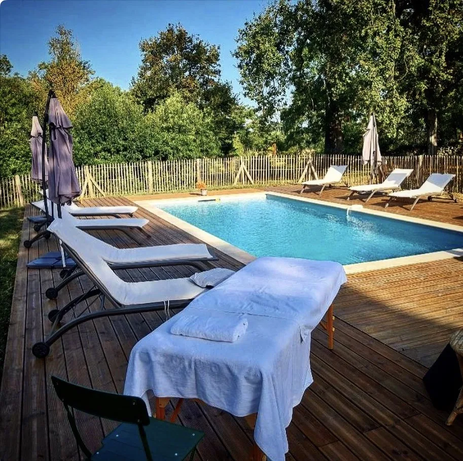 Piscine et table de massage sur la terrasse en bois du Clos Boissière