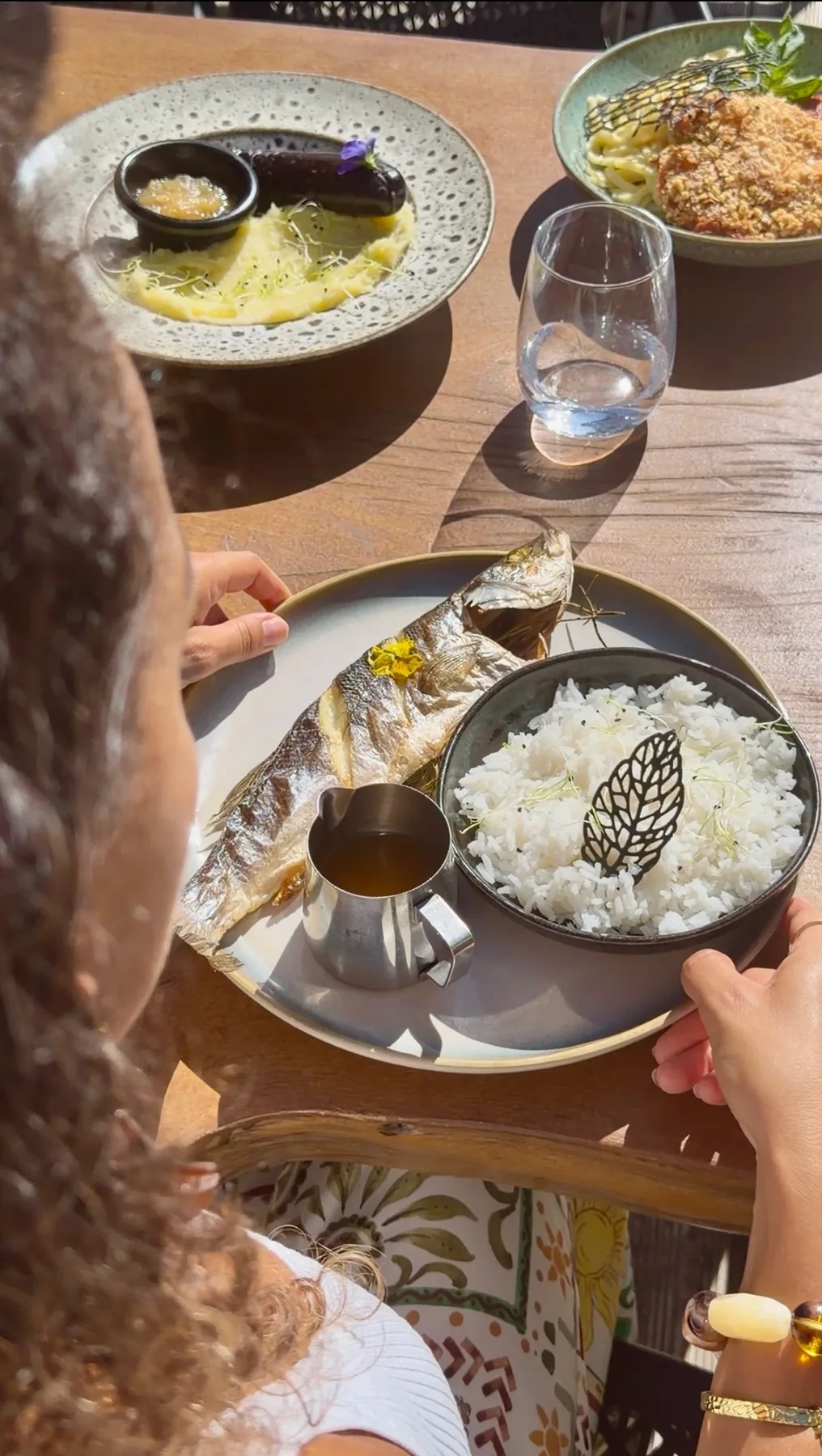 Poisson entier, riz et assiettes de saison servis en terrasse