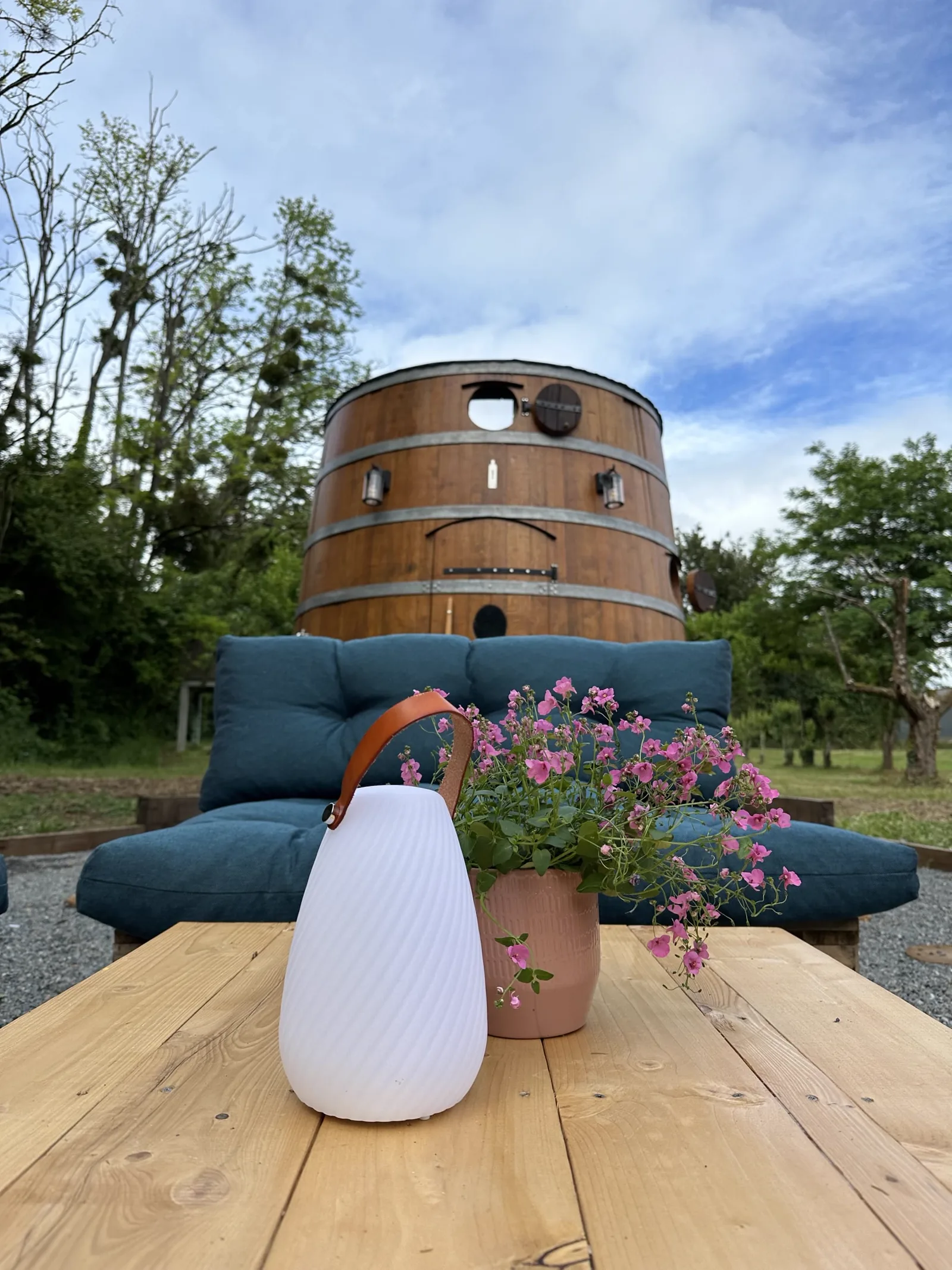 La terrasse en palettes et le salon de jardin devant le foudre du Domaine d’Arpaillan
