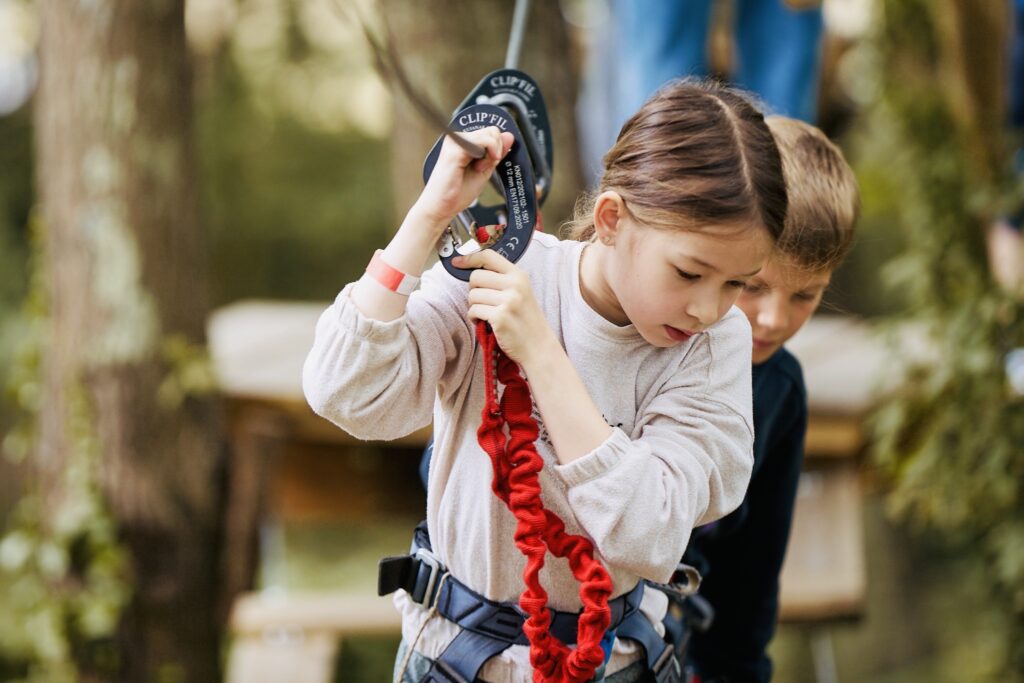 Enfant harnachée sur une tyrolienne en forêt, photo d’illustration fournie par Christian