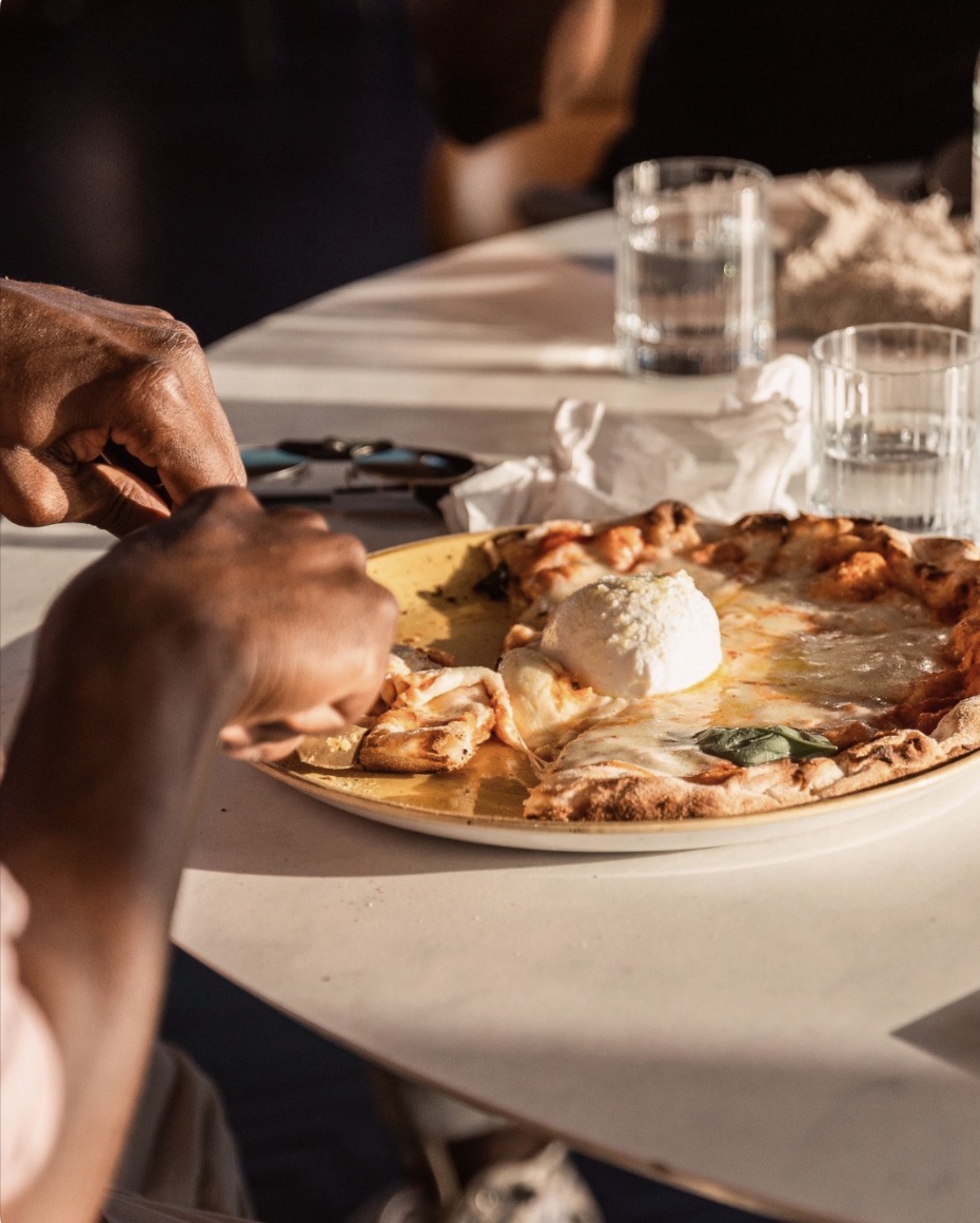 Pizza à la burrata servie en terrasse chez GINA Bordeaux