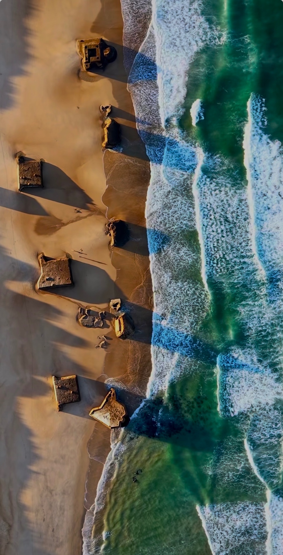 Surfeur sur la plage face à l'océan au coucher de soleil